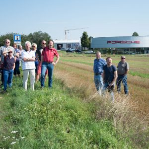 SPD-Mitglieder und interessierte Bürger im Gewerbegebiet Launsbach, im Hintergrund das Porschezentrum.